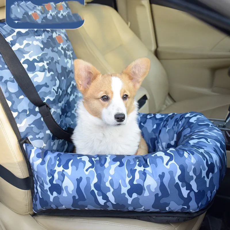 Dog sitting in a blue camouflage car seat in a vehicle.