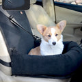 Dog sitting in a black pet seat cover inside a car