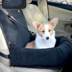 Dog sitting in a black pet seat cover inside a car