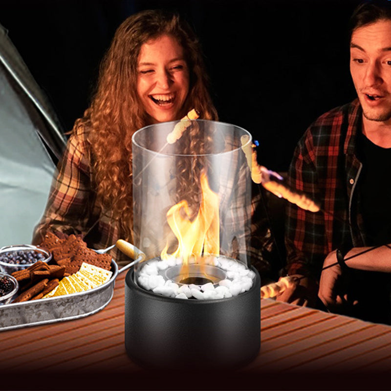 Two people roasting marshmallows over a portable fire pit at night.