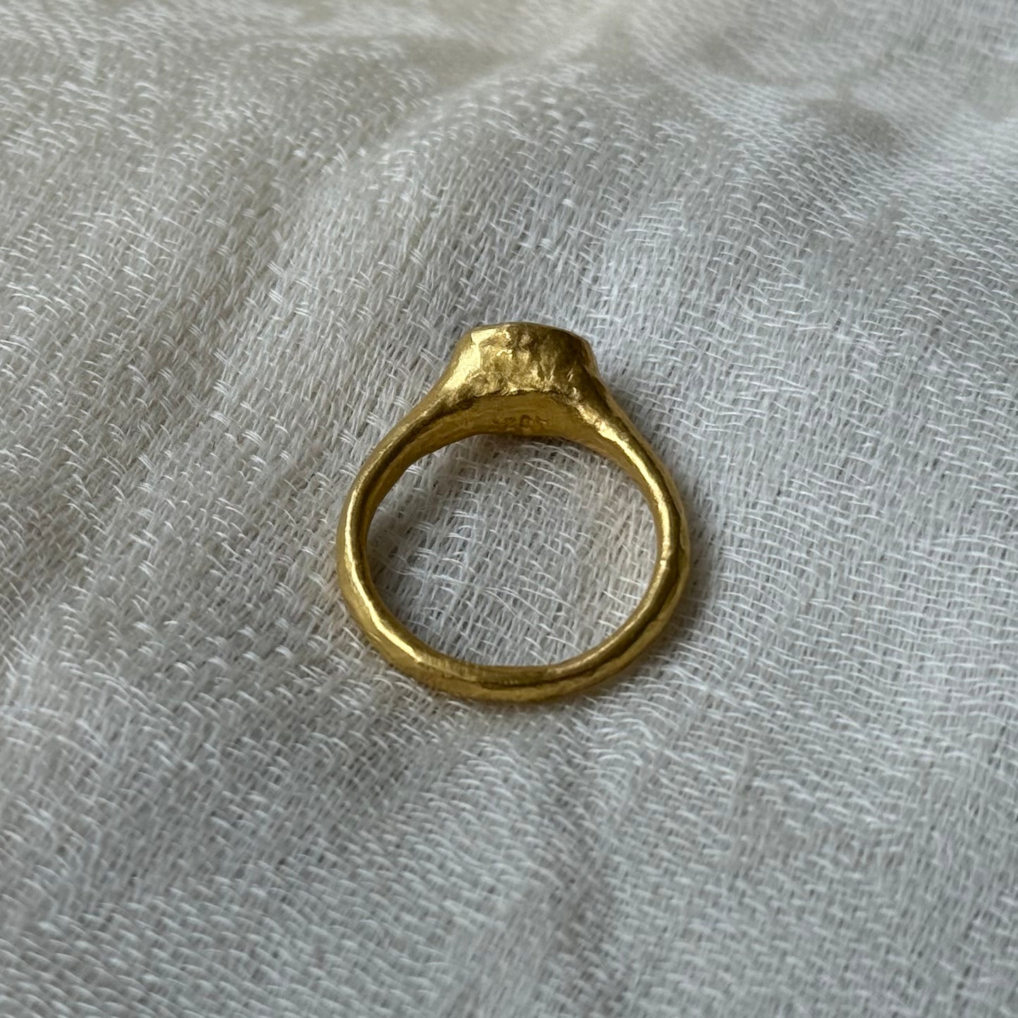 22ct Gold ring on a textured gray fabric background