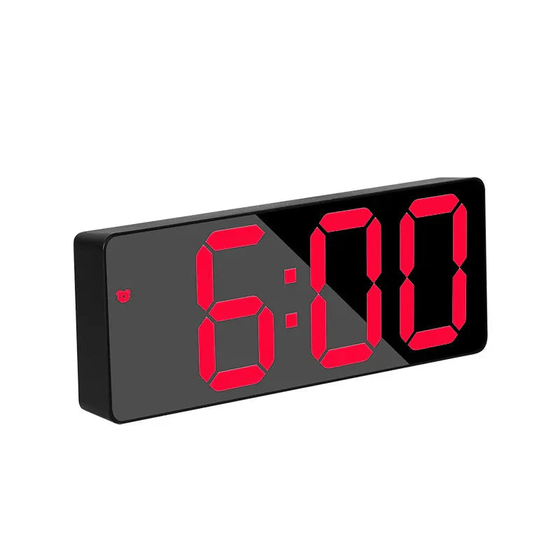 Digital clock with red LED display showing 6:00 on a white background