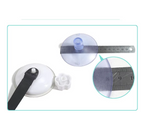 Close-up of a suction cup with a ruler for scale on a white background