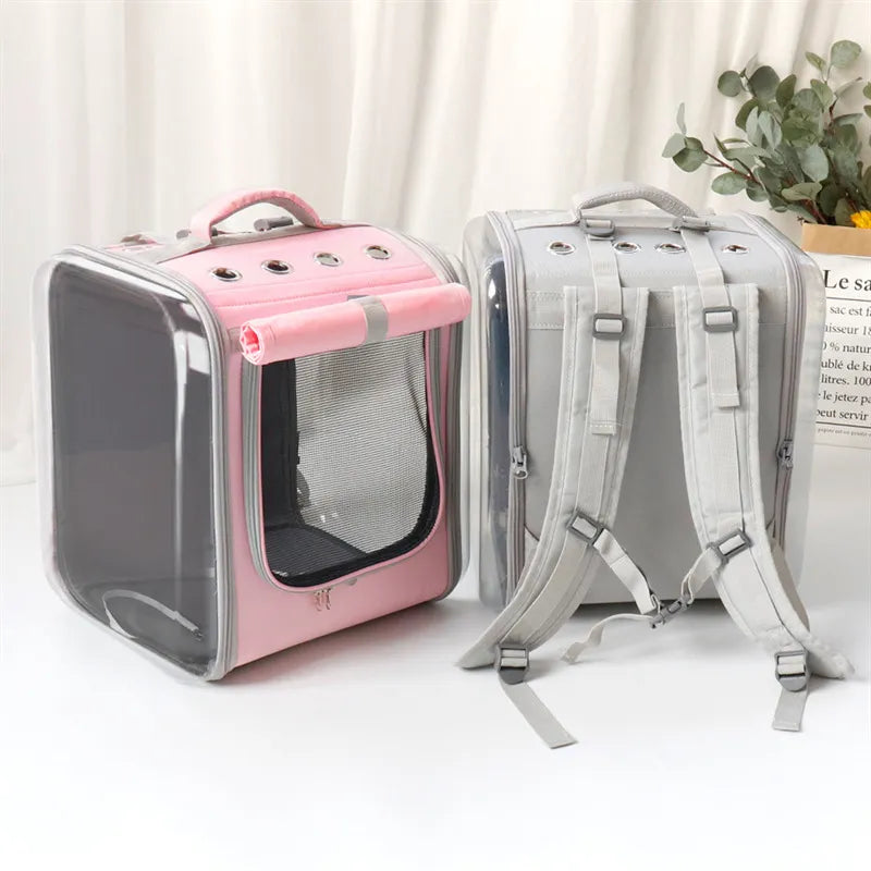 Pink and gray pet carriers on a white surface with a light curtain background