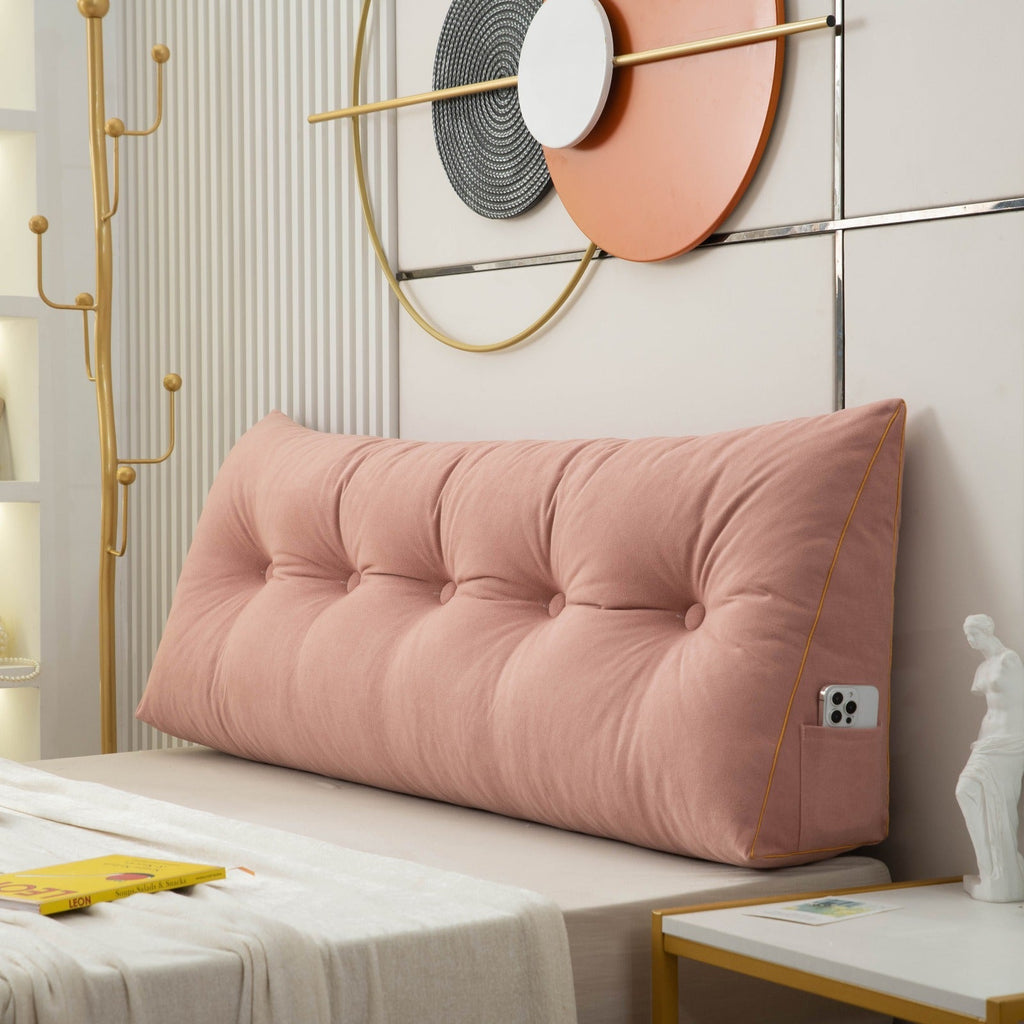 Pink headboard pillow on a bed with decorative wall art in the background