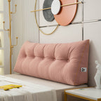 Pink headboard pillow on a bed with decorative wall art in the background