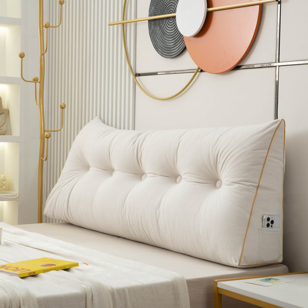 White tufted headboard pillow on a bed with decorative wall art in the background.