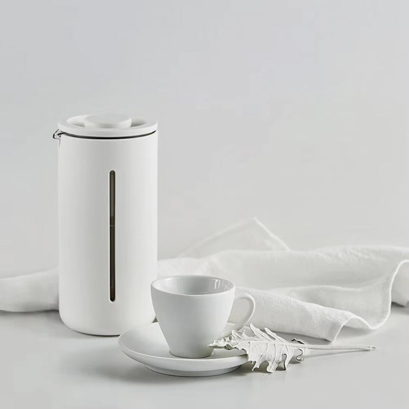White ceramic teapot and cup set on a light gray background