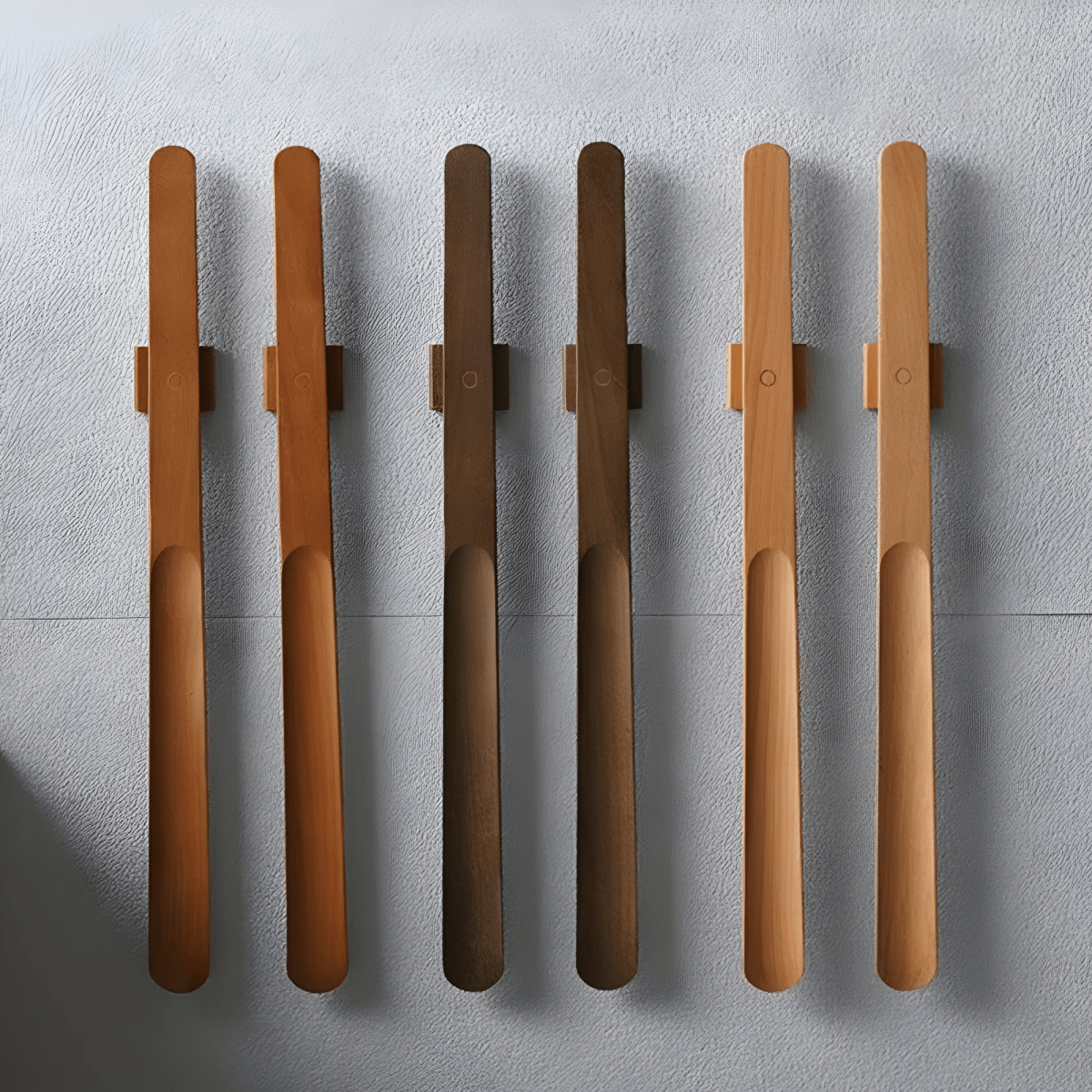 Set of six wooden spoons with metal handles on a gray surface