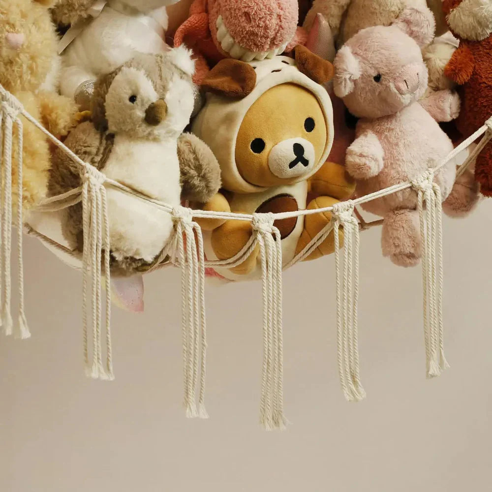 Collection of plush toys hanging on a string against a neutral background