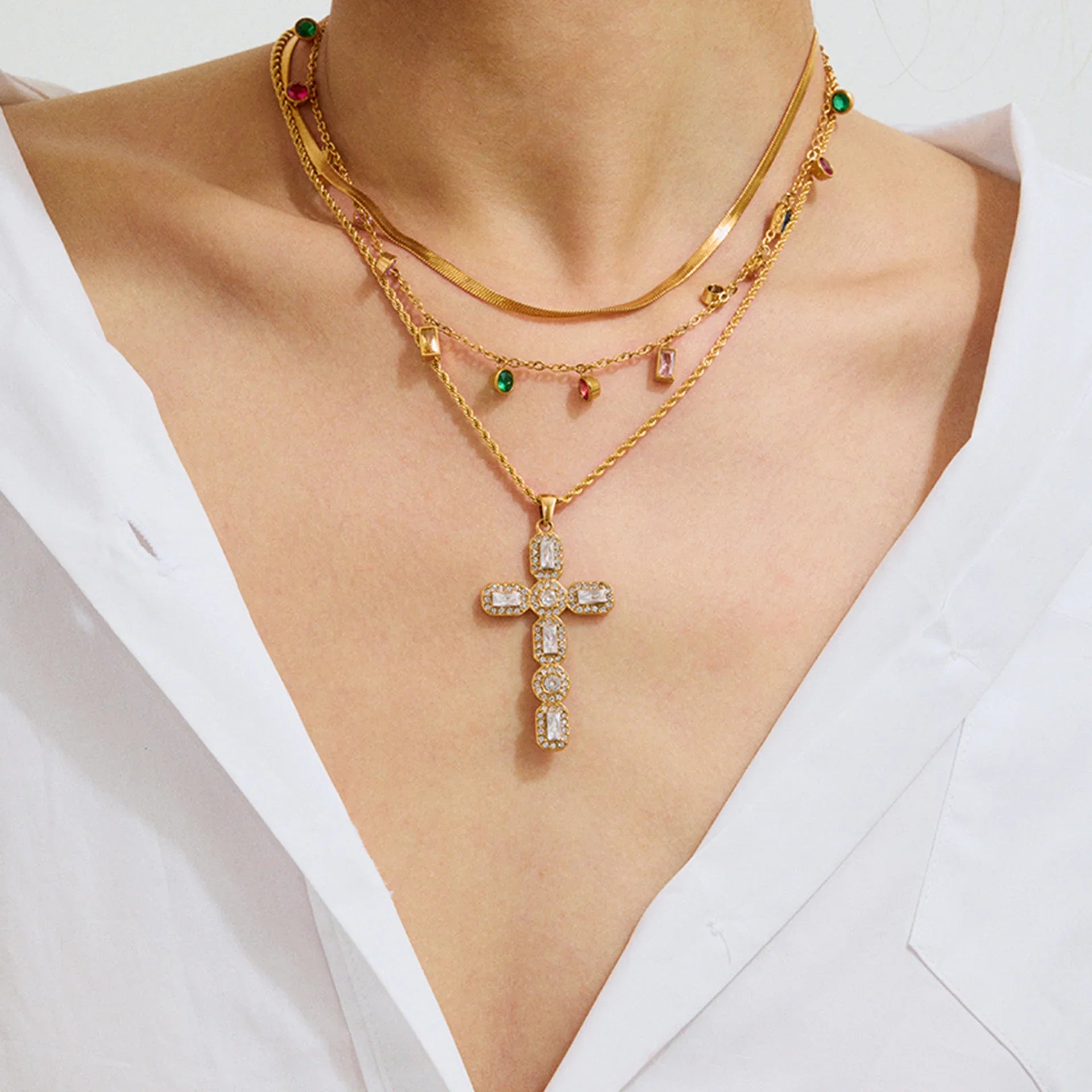 Gold necklace with a cross pendant on a white background