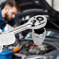 Close-up of a ratchet wrench with a blurred background of a person working on a car engine.
