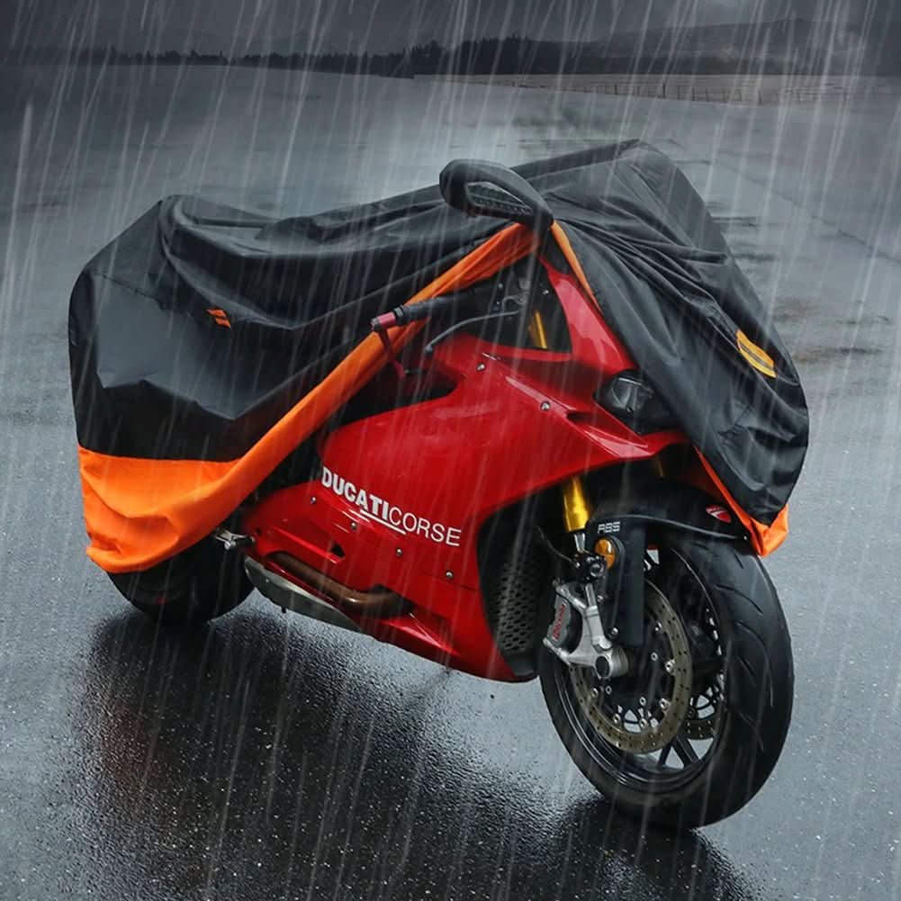 Red Ducati motorcycle under a black and orange cover in the rain.