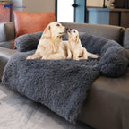 Two dogs on a fluffy gray pet bed in a living room setting.