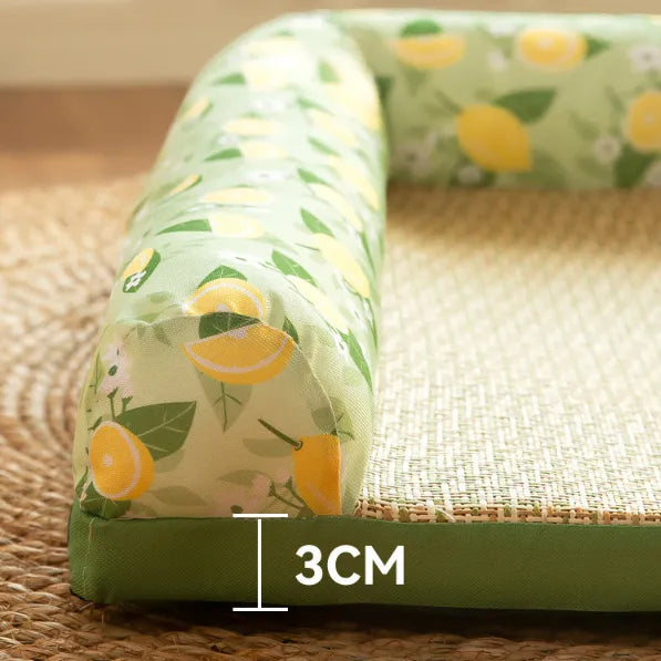 Green U-shaped pillow with lemon pattern on a woven mat