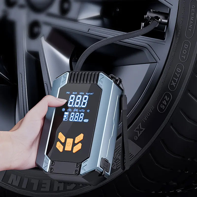 Digital tire pressure monitor held by a hand with a car tire in the background