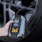 Digital tire pressure monitor held by a hand with a car tire in the background