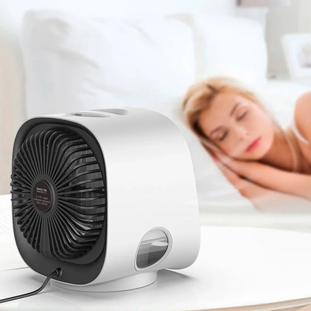 Small fan on a surface with a blurred background of a person lying down.