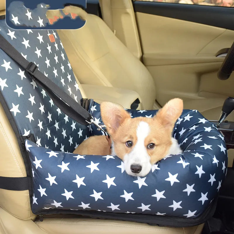 Dog sitting in a blue star-patterned car seat in a vehicle.