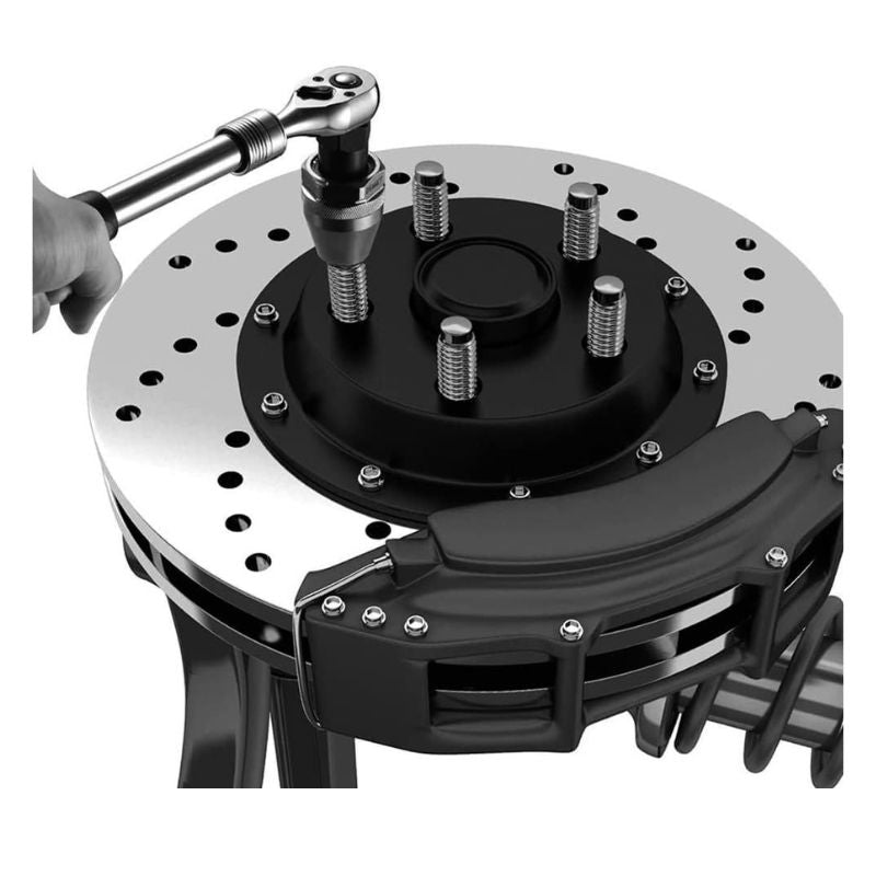 Close-up of a brake rotor with a hand using a wrench on a white background