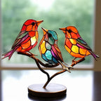Colorful stained glass birds on a branch with a blurred window background