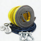 Coiled gray and yellow tow rope with metal hooks on a white background