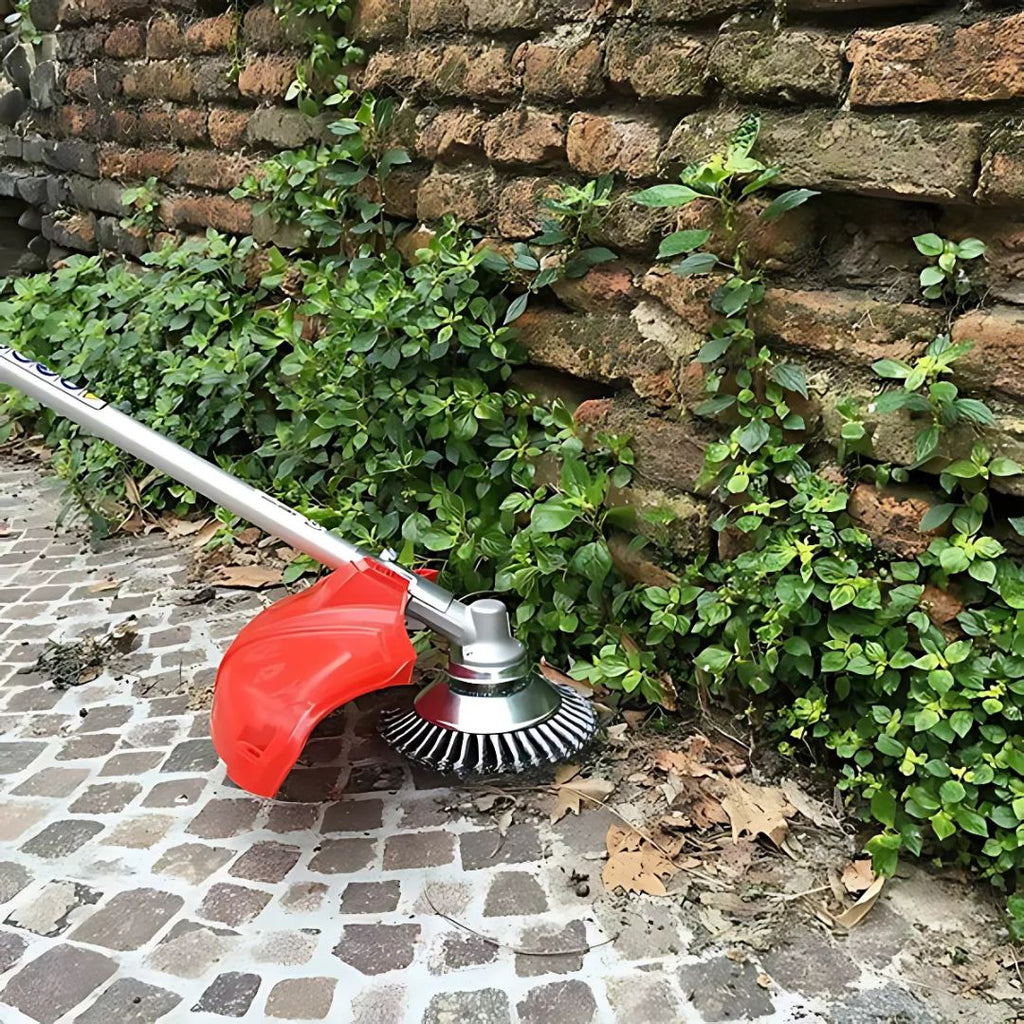Gardening tool being used to trim plants against a brick wall.