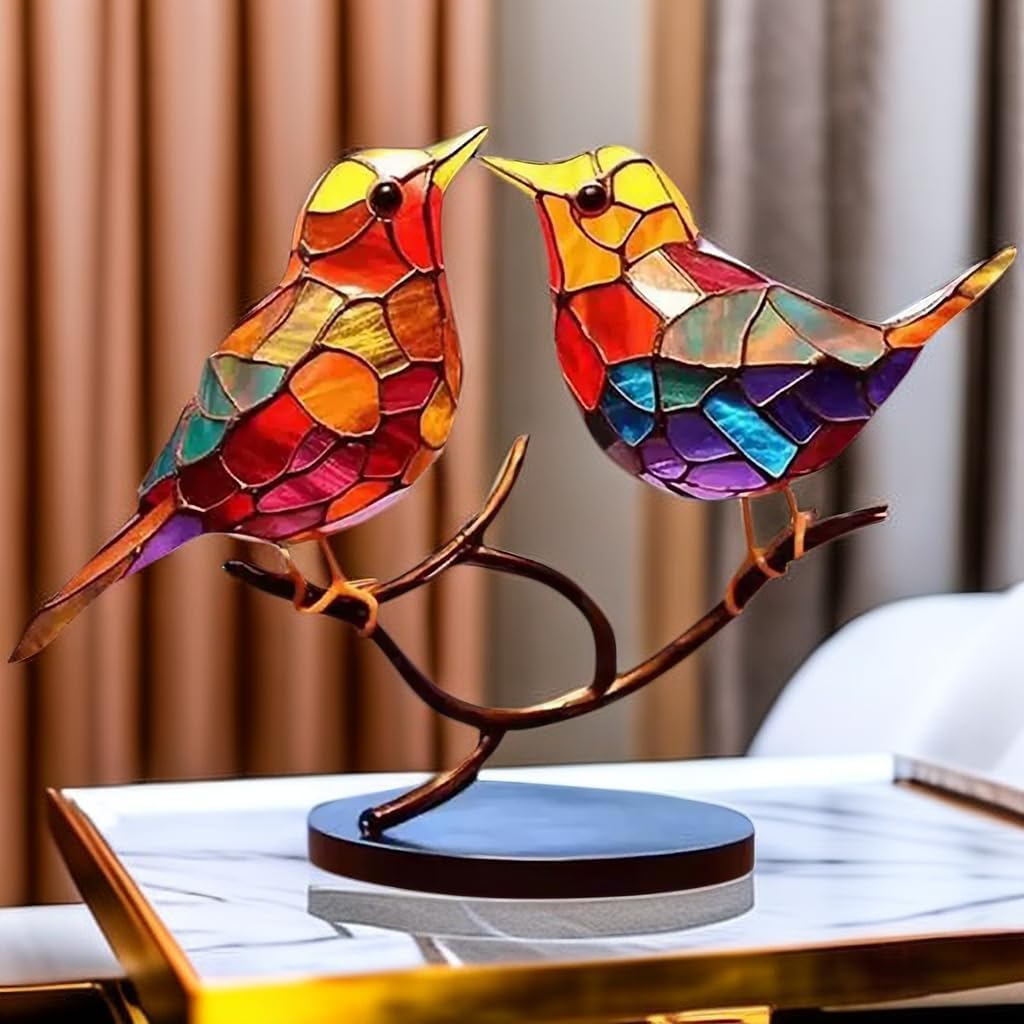 Colorful stained glass birds on a branch against a blurred curtain background