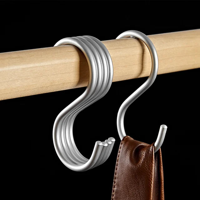 Metal S-hook attached to a wooden rod with a black background