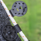 Close-up of a black metal clip attached to a white rope with orange accents, against a blurred green background.