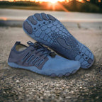 Blue athletic shoes on a concrete surface with a sunset in the background