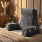 Gray folding chair with armrests on a bed in a cozy room.