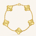 Gold bracelet with floral designs on a white background
