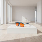 Sunglasses with orange lenses on a white platform in a modern room with large windows.