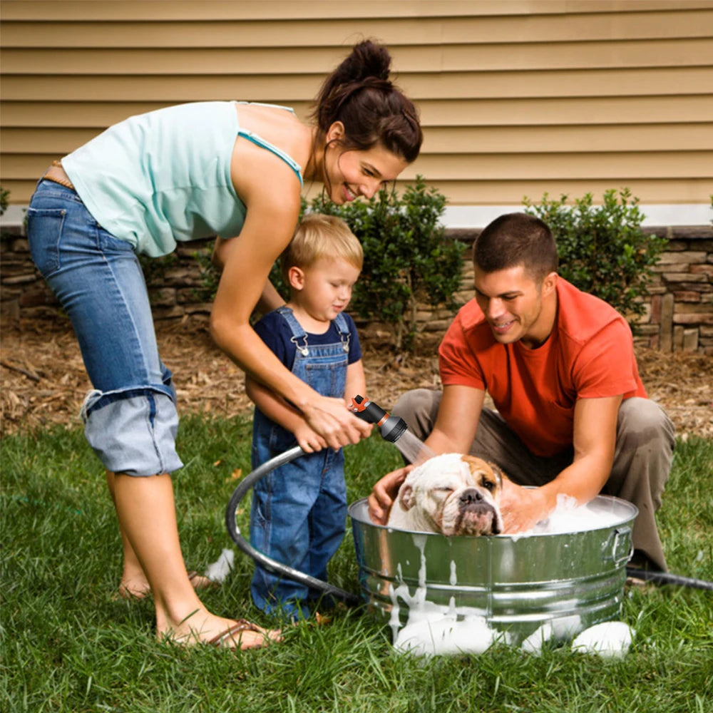 Family washing a dog in a metal tub outdoors.