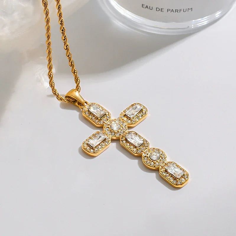 Gold cross necklace with gemstones on a white background